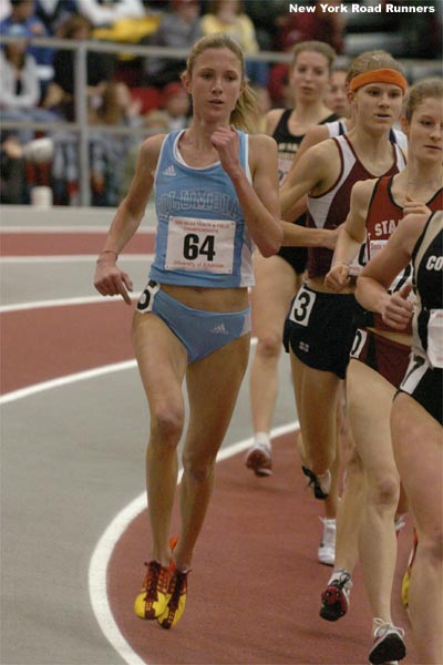 Caroline Bierbaum runs on the outside of lane one, in third place.