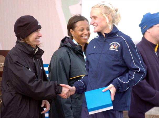 Winner Johanna Nilsson shakes hands with former NCAA great Caroline Zajac-Tynan (who was known as Carole Zajac when she was in the NCAA).